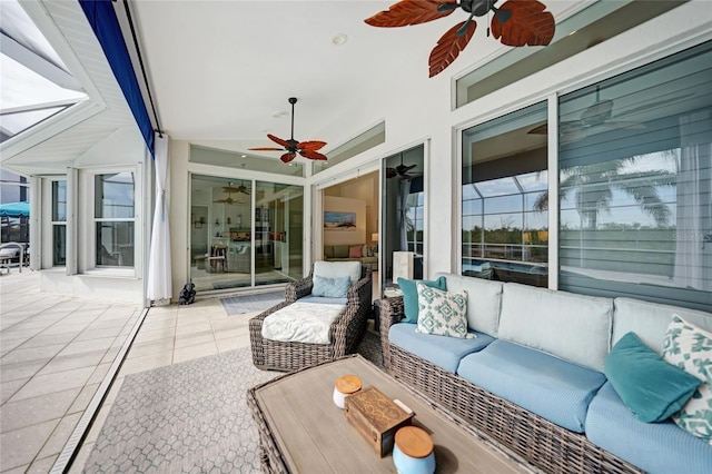 view of patio with an outdoor living space, ceiling fan, and glass enclosure