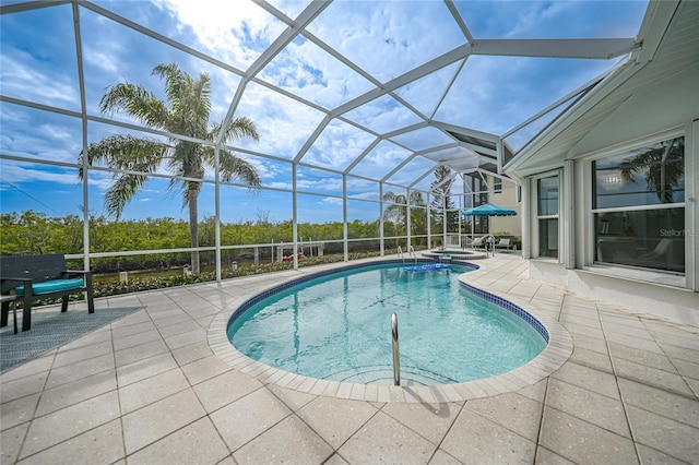 view of pool featuring a patio, an in ground hot tub, and glass enclosure