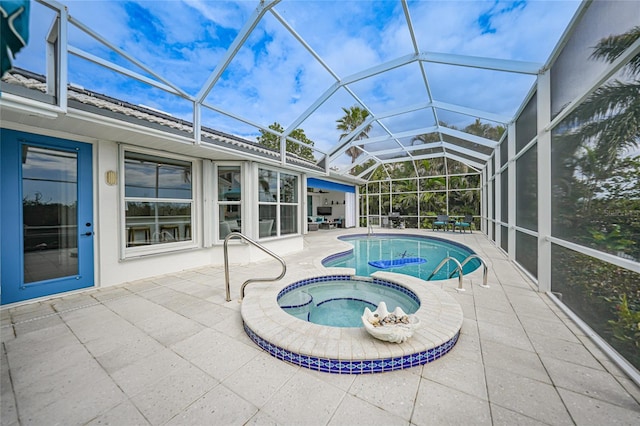 view of swimming pool with an in ground hot tub, glass enclosure, and a patio area