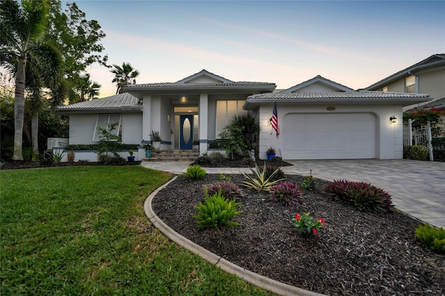 view of front of home featuring a garage and a lawn