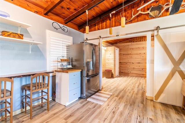 kitchen featuring a barn door, butcher block counters, stainless steel fridge with ice dispenser, and wooden ceiling