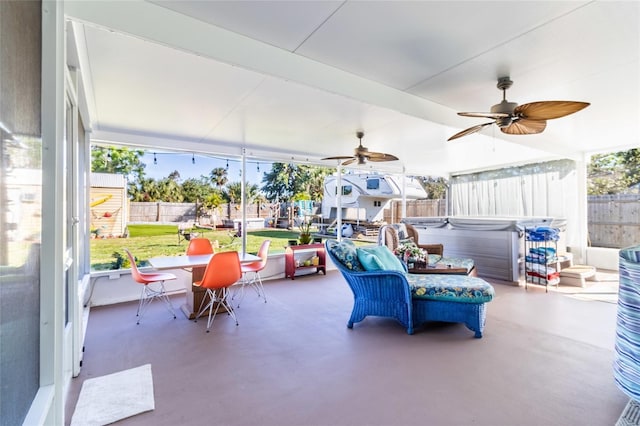 view of patio / terrace featuring ceiling fan and a hot tub