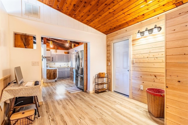 hall with lofted ceiling, light wood-type flooring, wooden walls, and wood ceiling