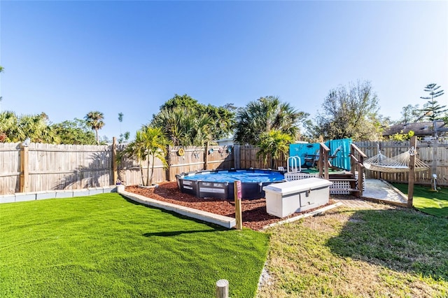 view of playground featuring a fenced in pool and a yard