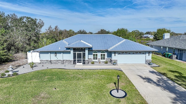 view of front of home featuring central AC unit, a garage, and a front lawn