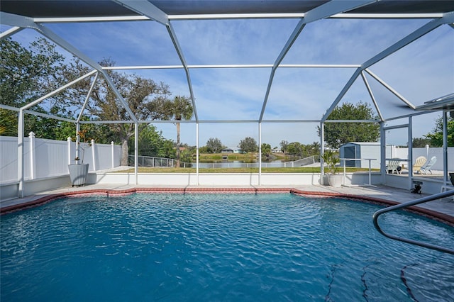 view of swimming pool with a patio, a water view, and a lanai