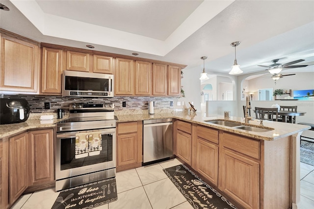 kitchen featuring sink, tasteful backsplash, kitchen peninsula, pendant lighting, and stainless steel appliances