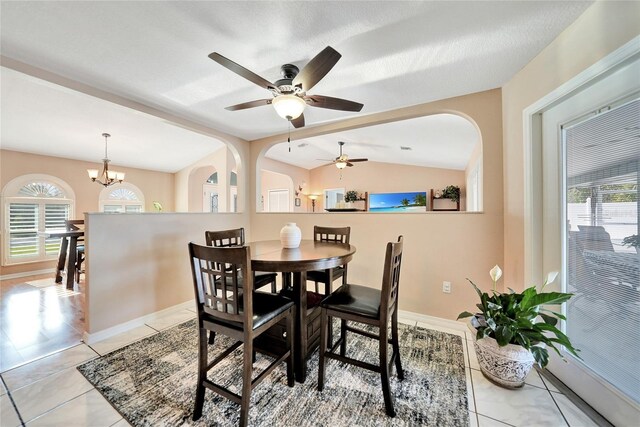 dining room featuring light tile patterned floors, a textured ceiling, vaulted ceiling, and a chandelier