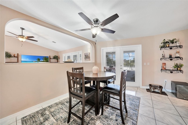 dining room with lofted ceiling, light tile patterned floors, ceiling fan, and french doors