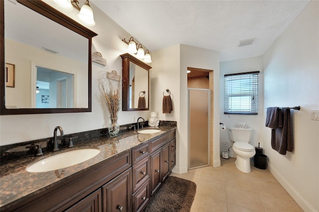 bathroom featuring tile patterned flooring, vanity, toilet, a shower with door, and a textured ceiling