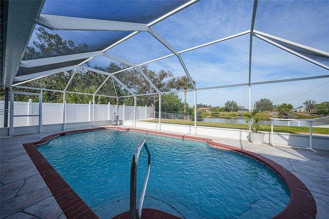 view of pool with a patio, a water view, and glass enclosure