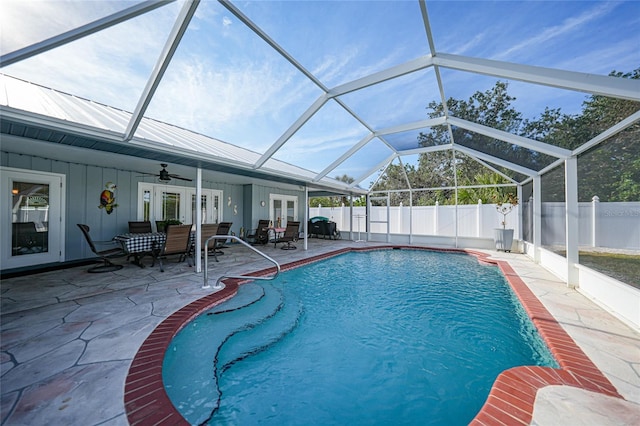 view of swimming pool with french doors, a patio, ceiling fan, and glass enclosure