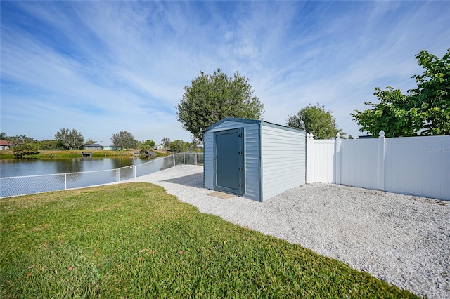 view of outdoor structure with a water view and a yard