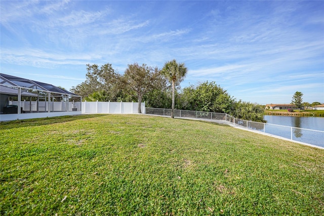 view of yard featuring a water view and glass enclosure