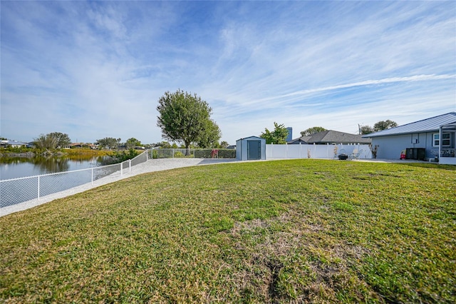 view of yard with a storage unit and a water view