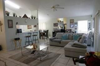 tiled living room with high vaulted ceiling and ceiling fan