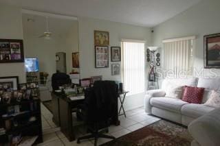 living room with light tile patterned floors and vaulted ceiling