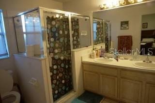 bathroom with vanity, an enclosed shower, and toilet