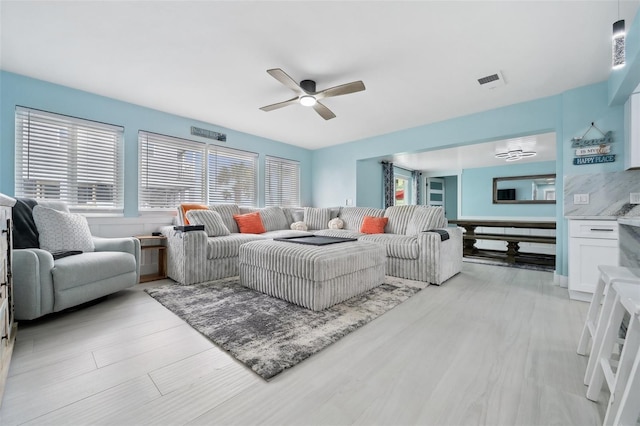 living room featuring ceiling fan and light wood-type flooring