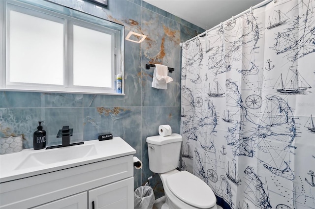 bathroom with vanity, tile walls, a shower with shower curtain, and toilet