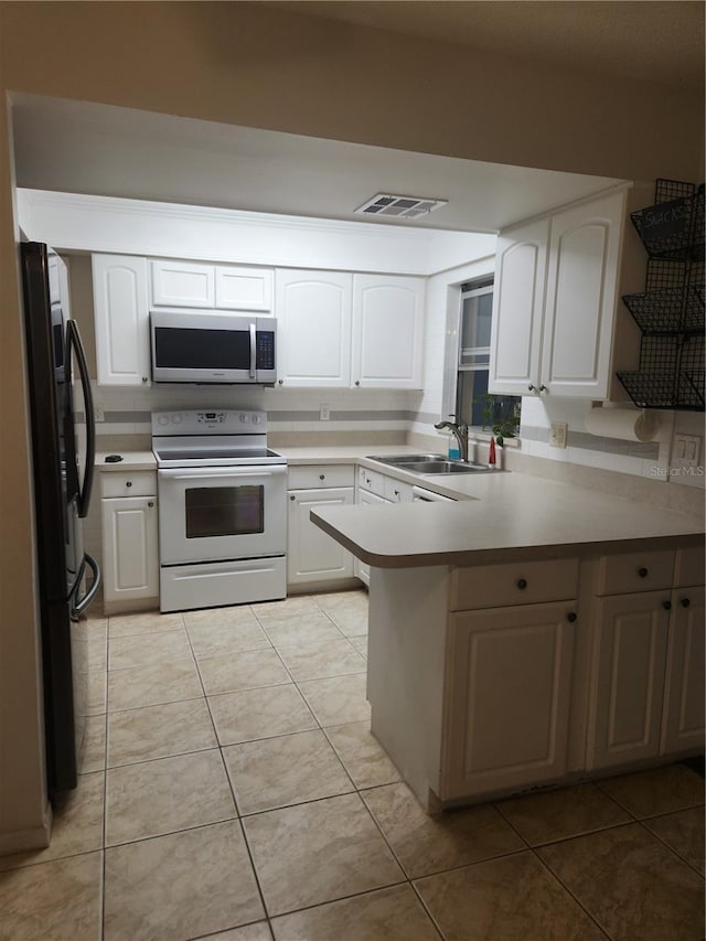 kitchen with black fridge, white electric stove, kitchen peninsula, and white cabinets