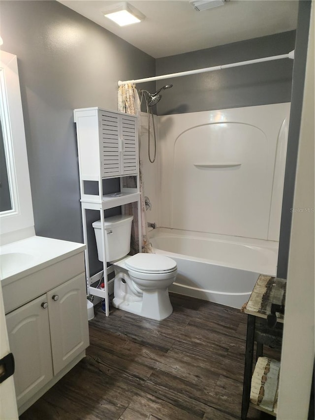 full bathroom with vanity, hardwood / wood-style floors, shower / bath combo, and toilet