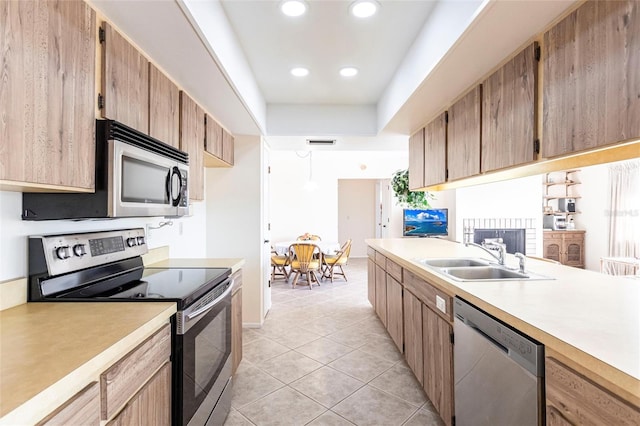 kitchen with stainless steel appliances, sink, and light tile patterned floors