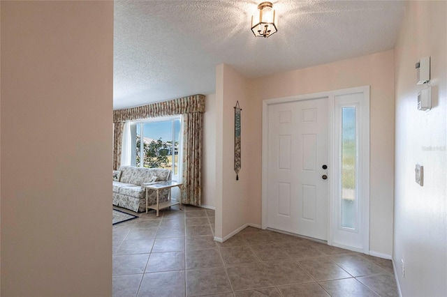 tiled entryway featuring a textured ceiling