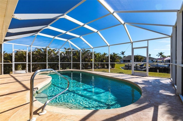 view of pool with glass enclosure and a patio area