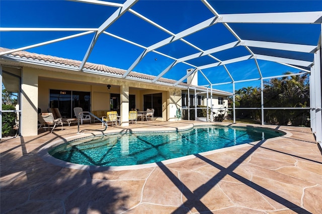 view of pool with a patio and glass enclosure