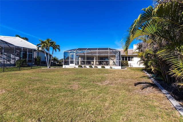 rear view of property featuring a lanai and a yard