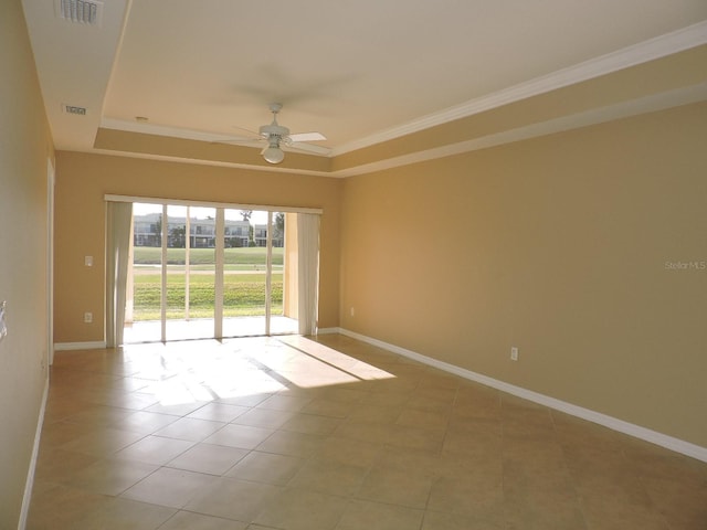 unfurnished room featuring a raised ceiling, ornamental molding, light tile patterned floors, and ceiling fan