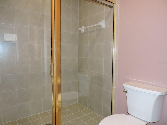 bathroom featuring a shower with shower door and toilet