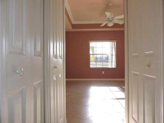 spare room featuring ceiling fan, ornamental molding, a tray ceiling, and light tile patterned floors