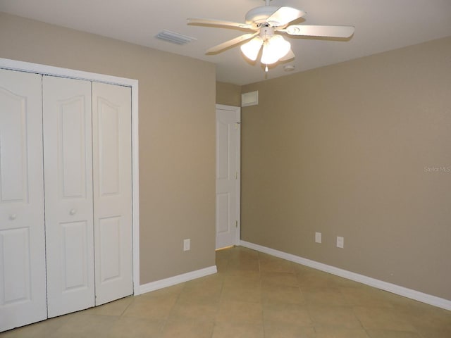 unfurnished bedroom with light tile patterned flooring, ceiling fan, and a closet