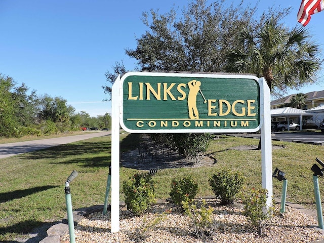 community sign featuring a lawn