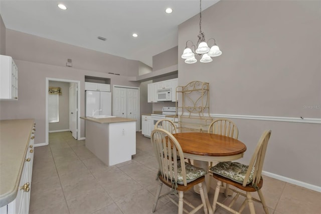 tiled dining room with an inviting chandelier and vaulted ceiling