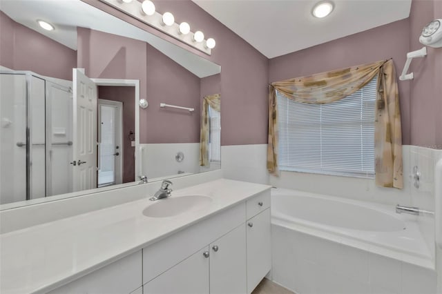 bathroom with vanity and shower with separate bathtub