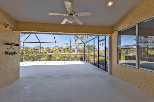 unfurnished sunroom with ceiling fan