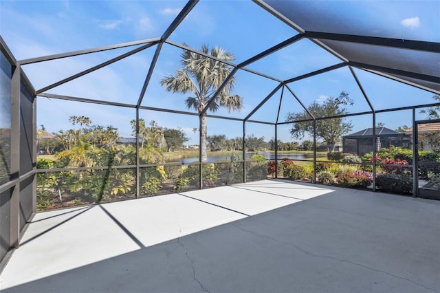 view of patio with a water view and glass enclosure