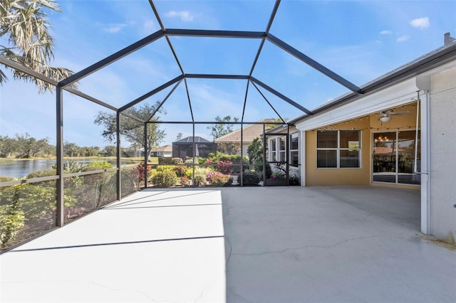 view of patio / terrace featuring a water view, ceiling fan, and a lanai