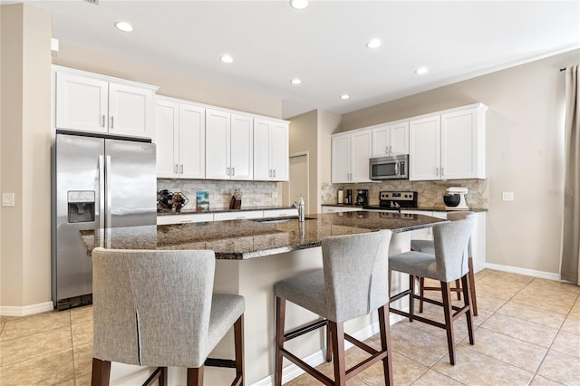 kitchen with white cabinetry, sink, a center island with sink, and appliances with stainless steel finishes