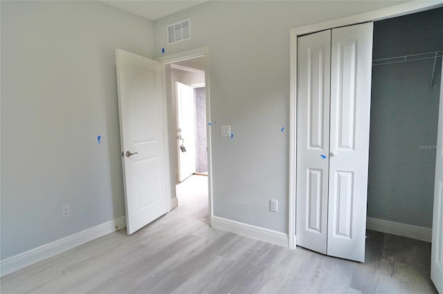 unfurnished bedroom with a closet and light hardwood / wood-style flooring