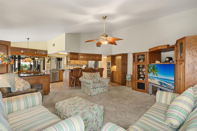 living room with high vaulted ceiling, light colored carpet, and ceiling fan