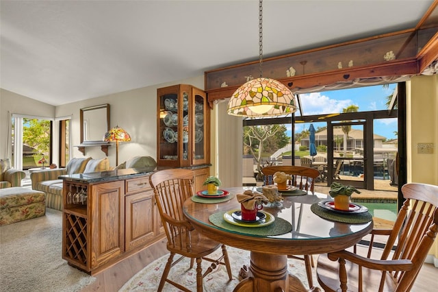 dining area featuring vaulted ceiling and light wood-type flooring