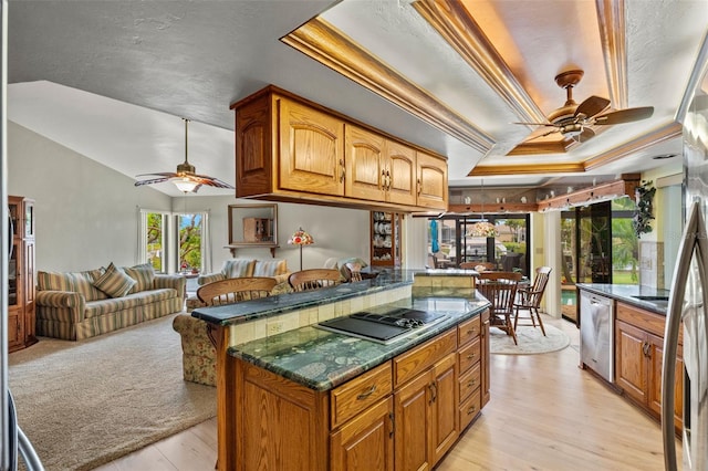 kitchen featuring a raised ceiling, black electric stovetop, stainless steel dishwasher, and ceiling fan