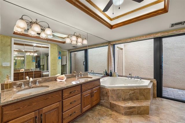 bathroom with ceiling fan, vanity, ornamental molding, tiled bath, and a raised ceiling