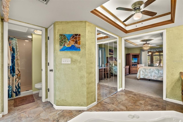 bathroom featuring crown molding, ceiling fan, toilet, and a raised ceiling