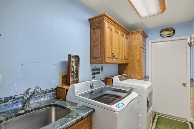 clothes washing area featuring cabinets, washer and clothes dryer, and sink