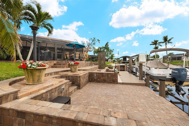 view of patio / terrace with a lanai and a dock